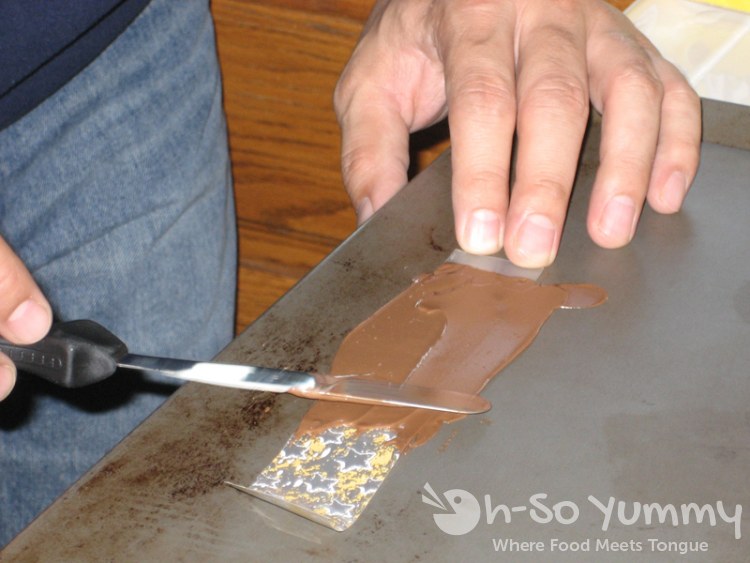 Spreading chocolate on a strip of the transfer sheet Spreading chocolate on a strip of the transfer sheet